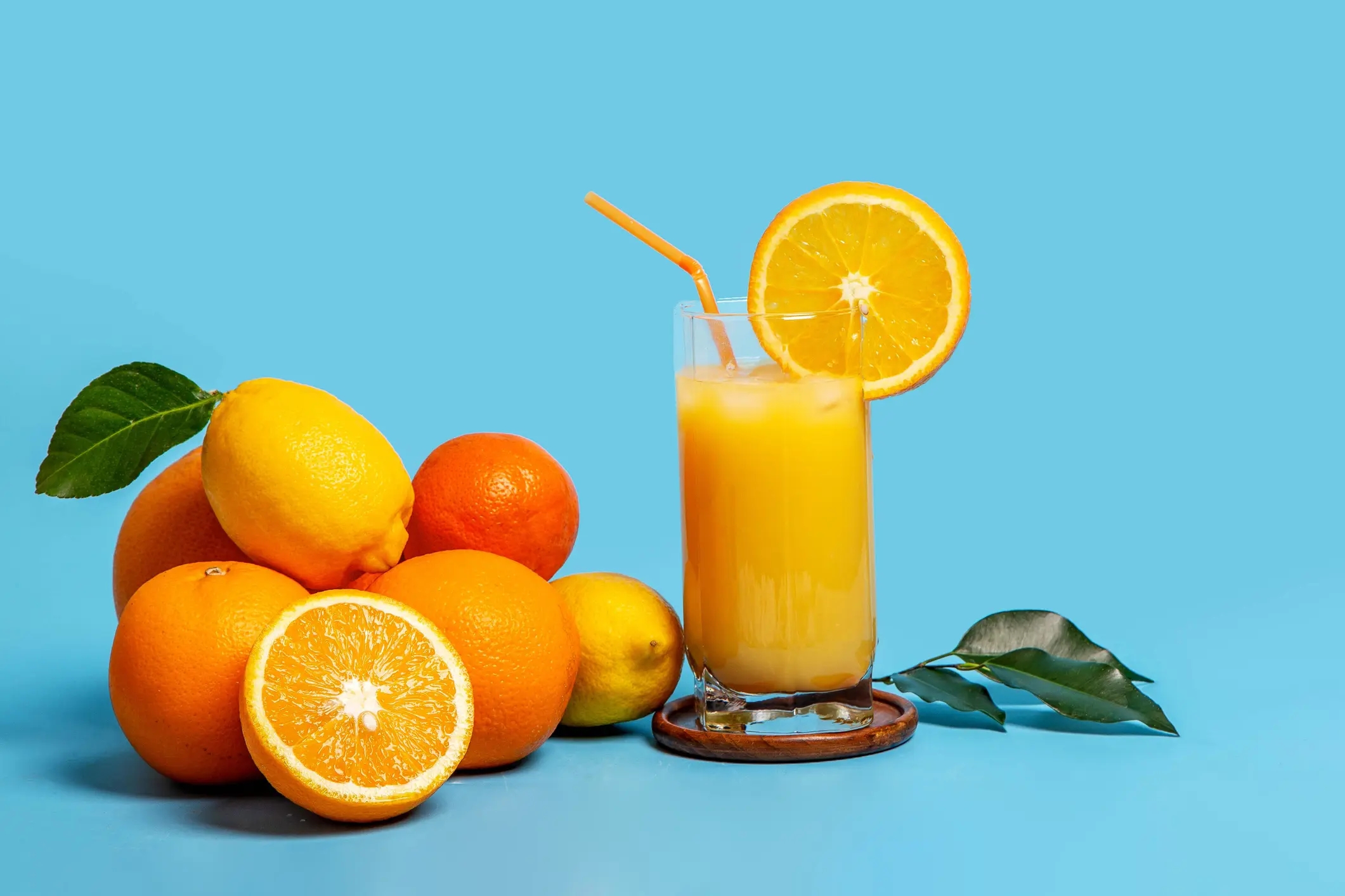 Fresh citrus fruits and a glass of orange juice, illustrating food and beverage powder applications requiring flowability and moisture control.
